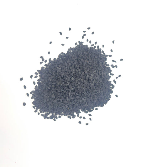 Pile of dark gray granules on a white background