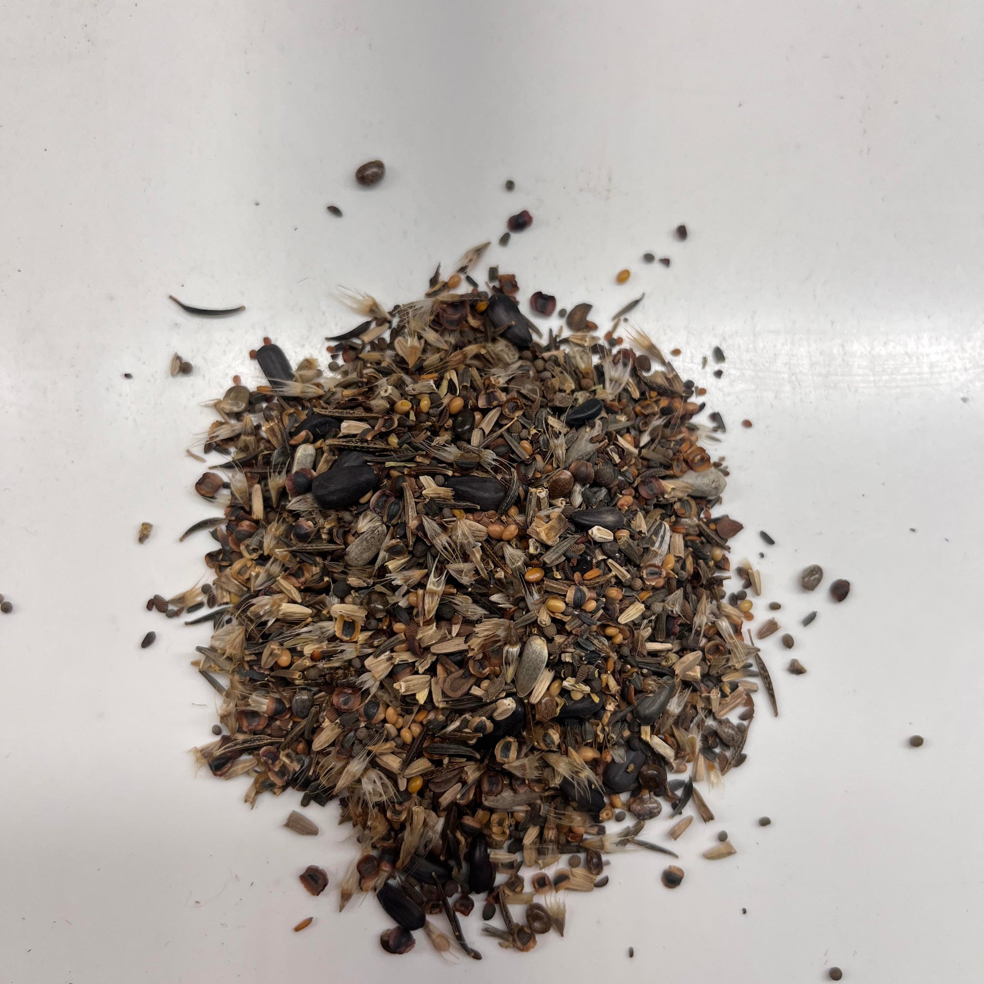 heap of bee feed mix on a white surface