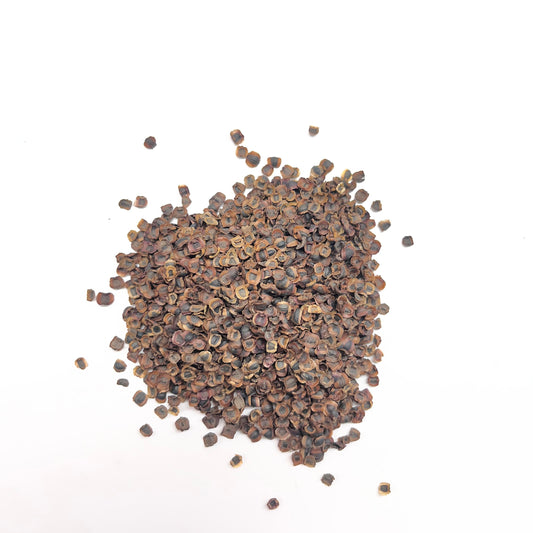 Small pile of dark brown seeds on a white background